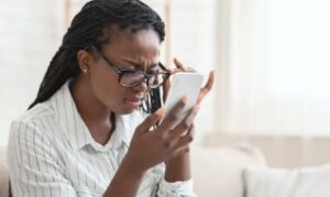 Woman having difficulty reading phone